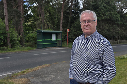 Andrew Barham standing by a local bus stop