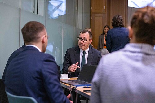 Tom Gordon sat round a table talking to a group of people