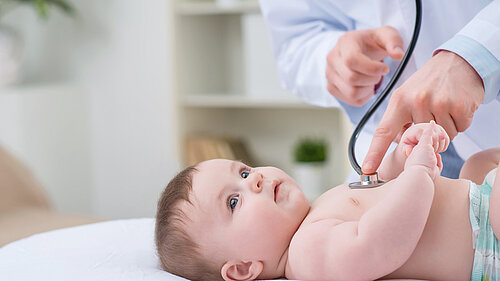 A baby being checked using a stethoscope.