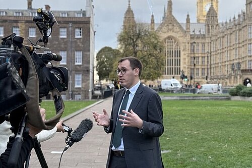 Tom Gordon stood outside Parliament talking to the media