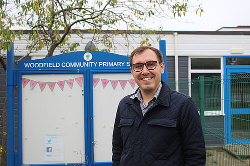 Tom Gordon MP standing in front of a primary school