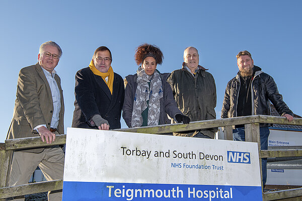 Teignmouth hospital sign with cllrs Cllrs Cox, Wrigley, Jeffries, Dewhirst, Henderson at Teignmouth Hospital