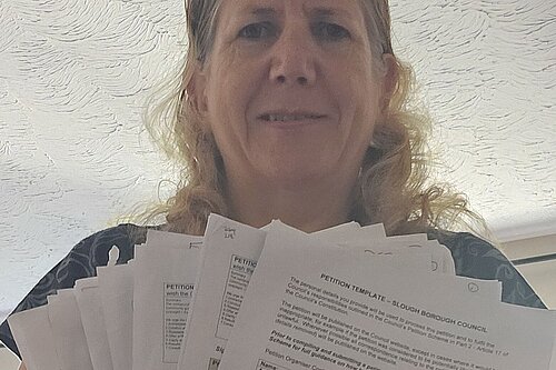 Jen Simpson with paper versions of petition submitted