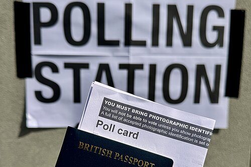 Polling station sign with poll card and passport