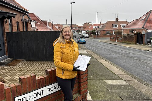 Julia Potts in St Gabriel's Estate holding up a grit bin petition