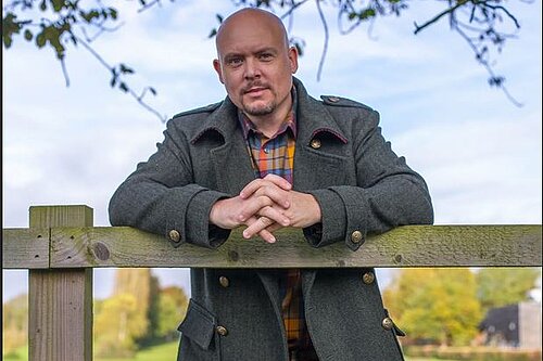 Cameron Thomas MP leaning on fence