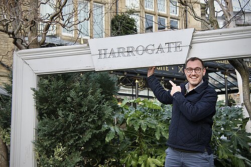 Tom Gordon MP under a sign saying Harrogate