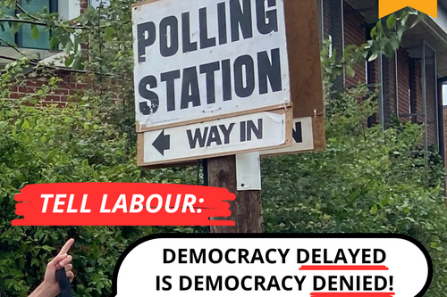 Graphic: 'Tell Labour Democracy Delayed is Democracy Denied' in front of a polling station sign