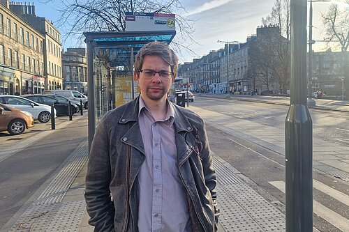Jack Caldwell standing in front of a bus stop with a cycle lane at either side