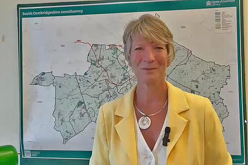 Pippa Heylings speaks in front of a South Cambs constituency map