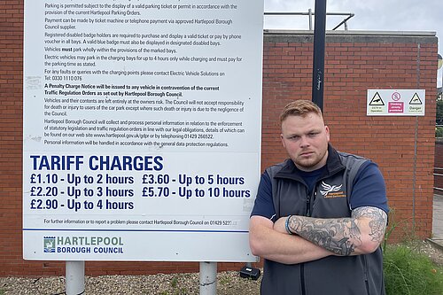 Connor Stallard with a Parking Charges board in Hartlepool town centre