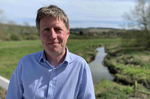 James on a sunny day with the Cuckmere river behind him.