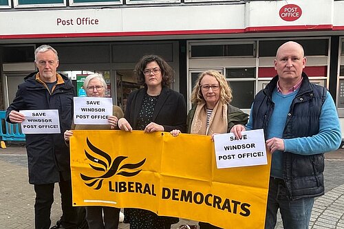 councillors outside windsor post office holding a lb dem banner