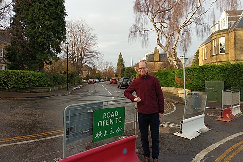 Neil standing next to a barrier