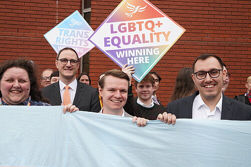Tom Gordon stood outside the Harrogate Convention Centre with LGBTQ+ signs and other Liberal Democrats