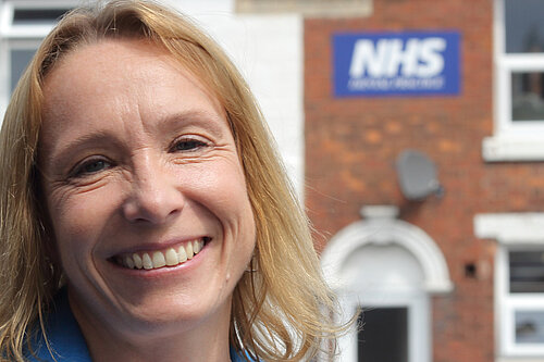 Helen standing in front of an NHS building